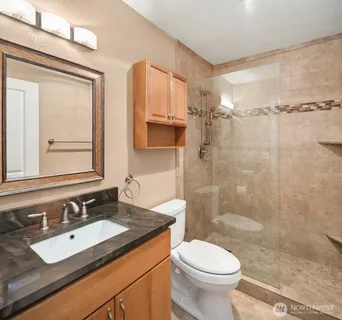 a bathroom with a sink toilet vanity and shower