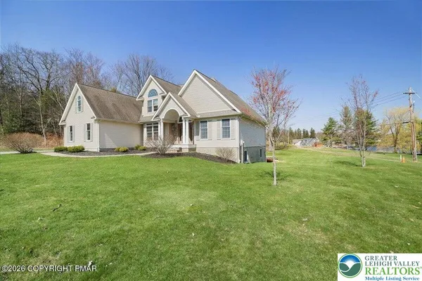 a front view of house with yard and green space
