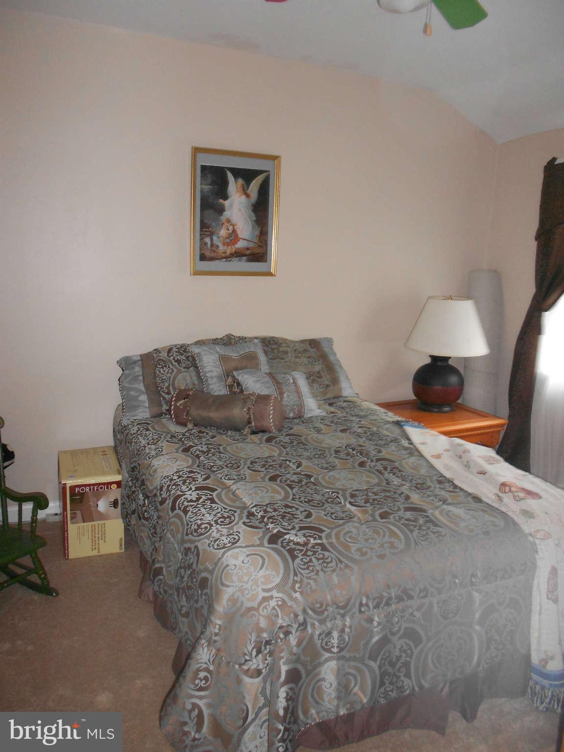 8162 Kavanagh Road Dundalk, MD 21222 - Photo 3 of 5 a bedroom with a bed and a lamp on dresser
