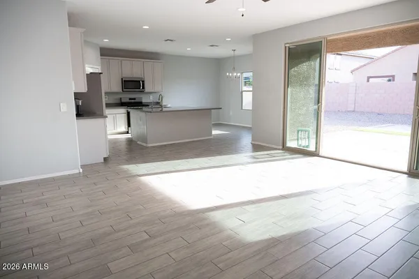a view of a kitchen with kitchen island a sink wooden floor and stainless steel appliances