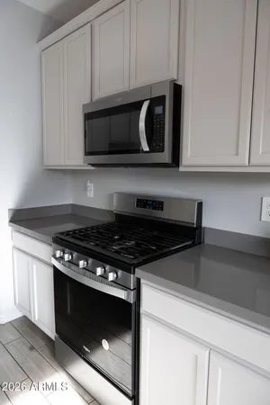 a kitchen with stainless steel appliances granite countertop white cabinets and black stove top oven with granite countertops