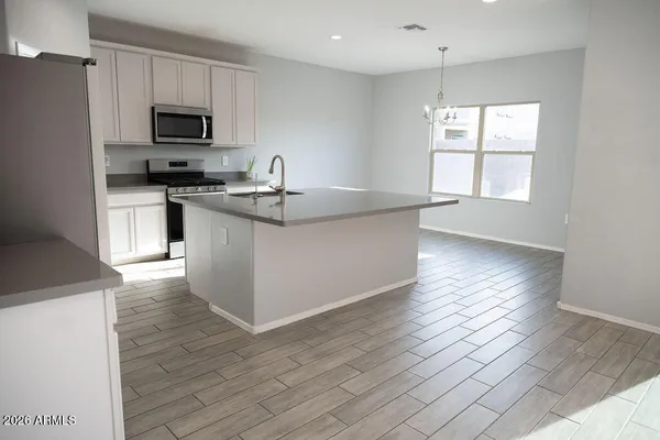 a kitchen with stainless steel appliances granite countertop a stove a sink and a microwave