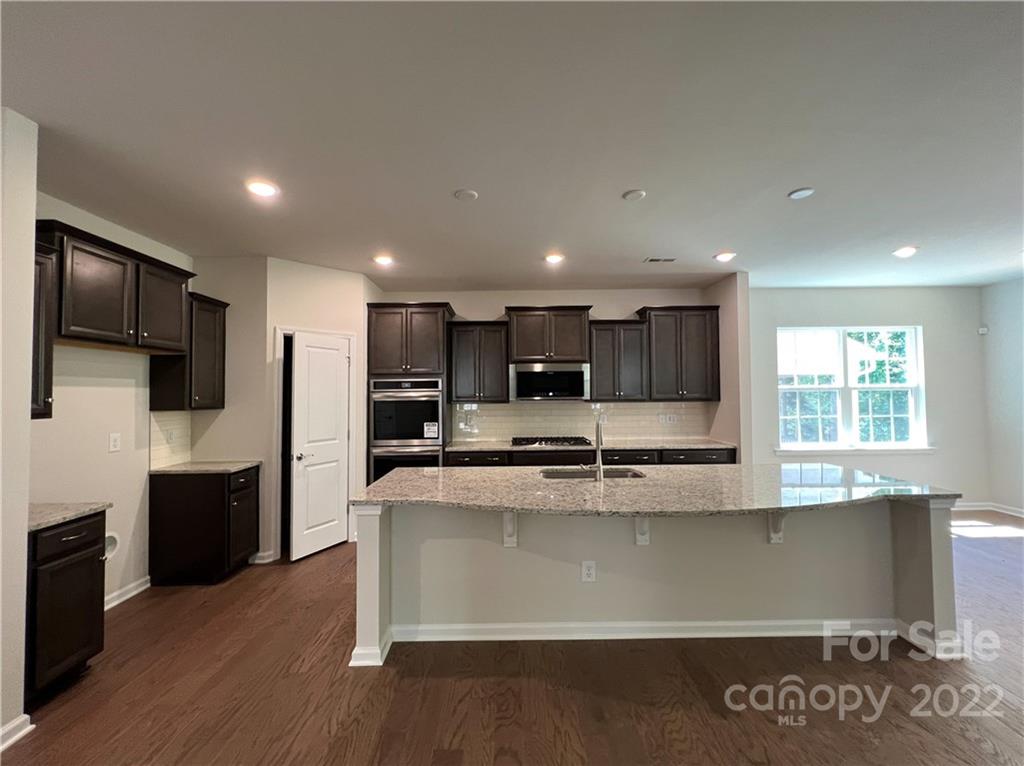 3155 Windhaven Lane, Unit 80 Tega Cay, SC 29708 - Photo 4 of 28 a large kitchen with kitchen island a large counter top stainless steel appliances and cabinets