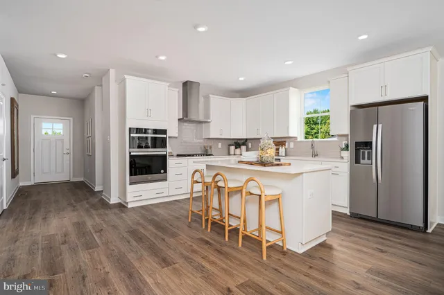 a kitchen with stainless steel appliances a refrigerator and a stove top oven