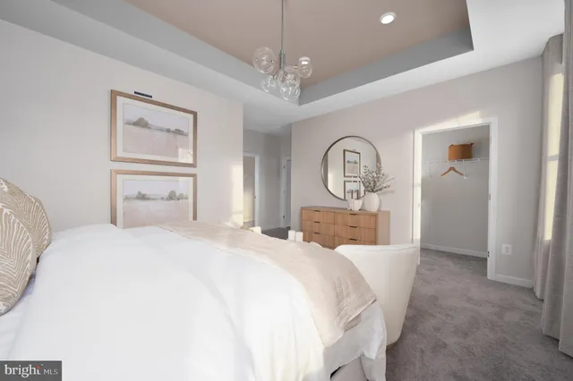 a bedroom with a large bed and a chandelier