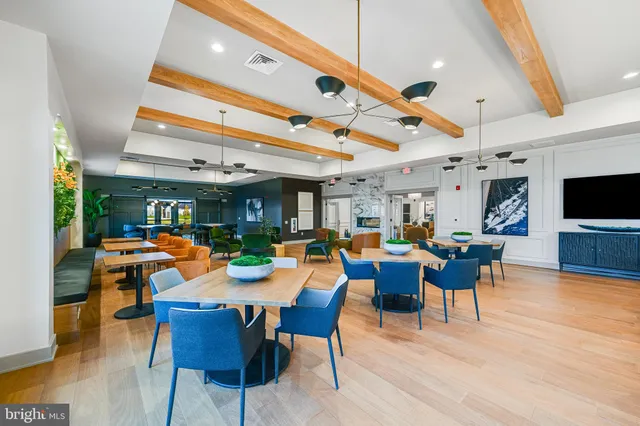 a dining room with wooden floor a chandelier a glass table and chairs