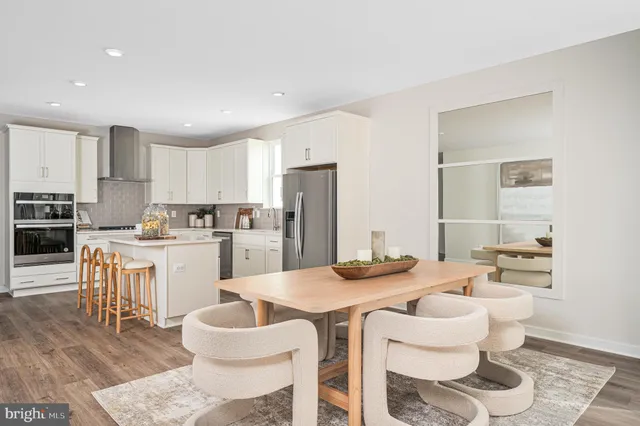 a kitchen with a dining table chairs and view living room