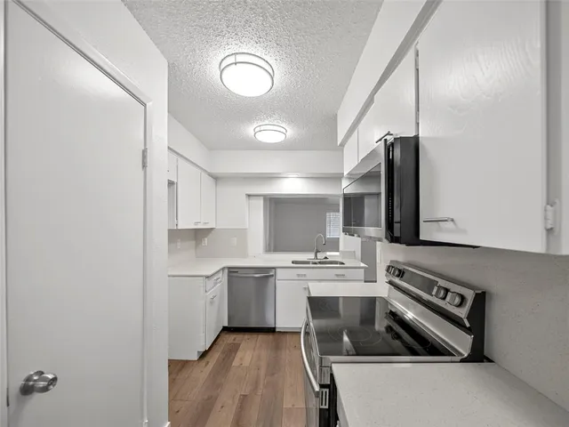 a kitchen with a sink stove top oven and cabinets