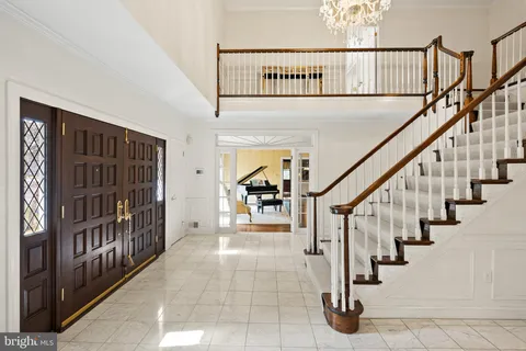 a view of staircase with lots of frames on wall and two windows