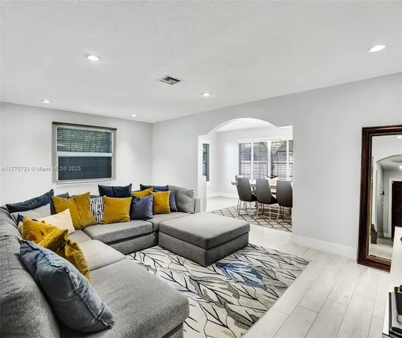 a living room with furniture and a wooden floor