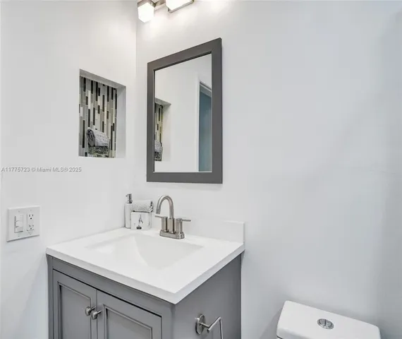 a bathroom with a sink vanity and mirror