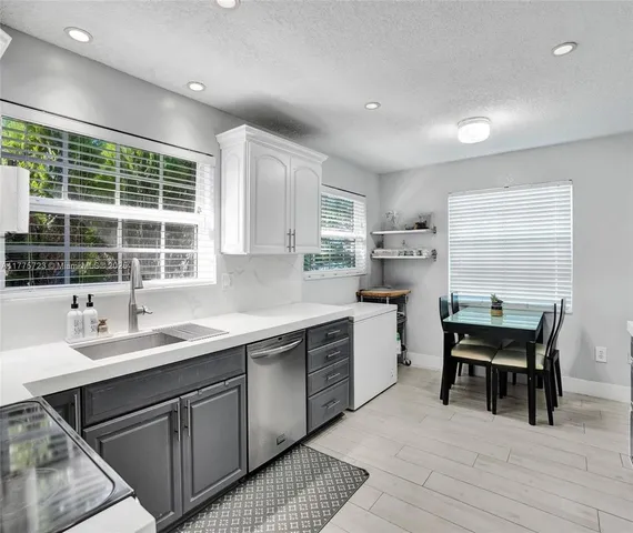 a kitchen with sink cabinets and dining table