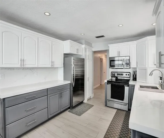 a kitchen with stainless steel appliances granite countertop a refrigerator and a stove top oven