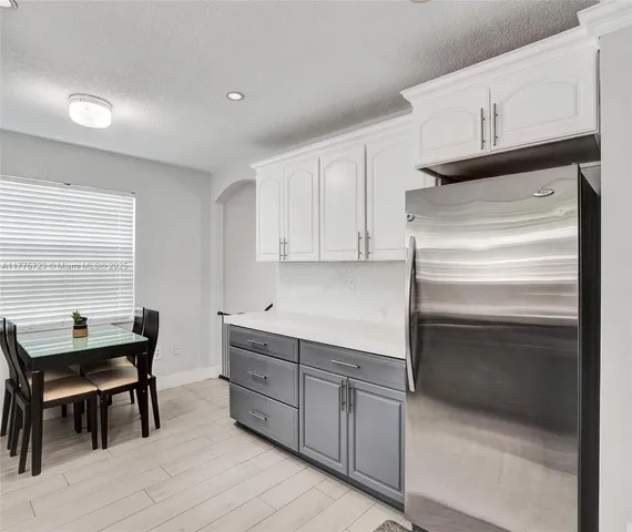 a kitchen with white cabinets and chair