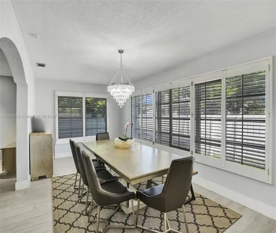 a view of a dining room with furniture wooden floor and chandelier