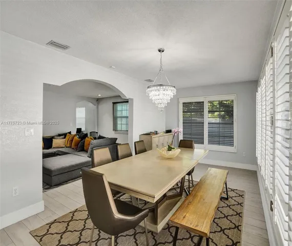 a view of a dining room with furniture wooden floor and chandelier