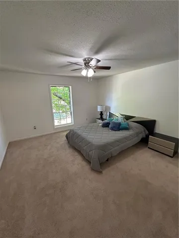 an empty room with windows and fan