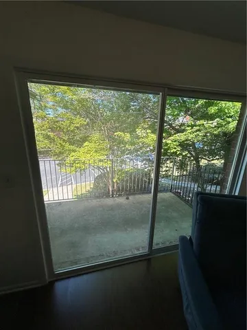 a view of empty room with wooden floor and floor to ceiling window