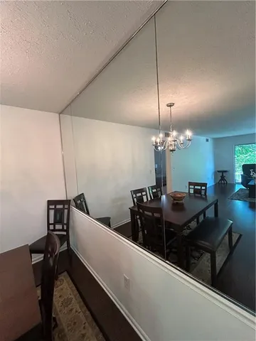 a living room with chairs and a chandelier