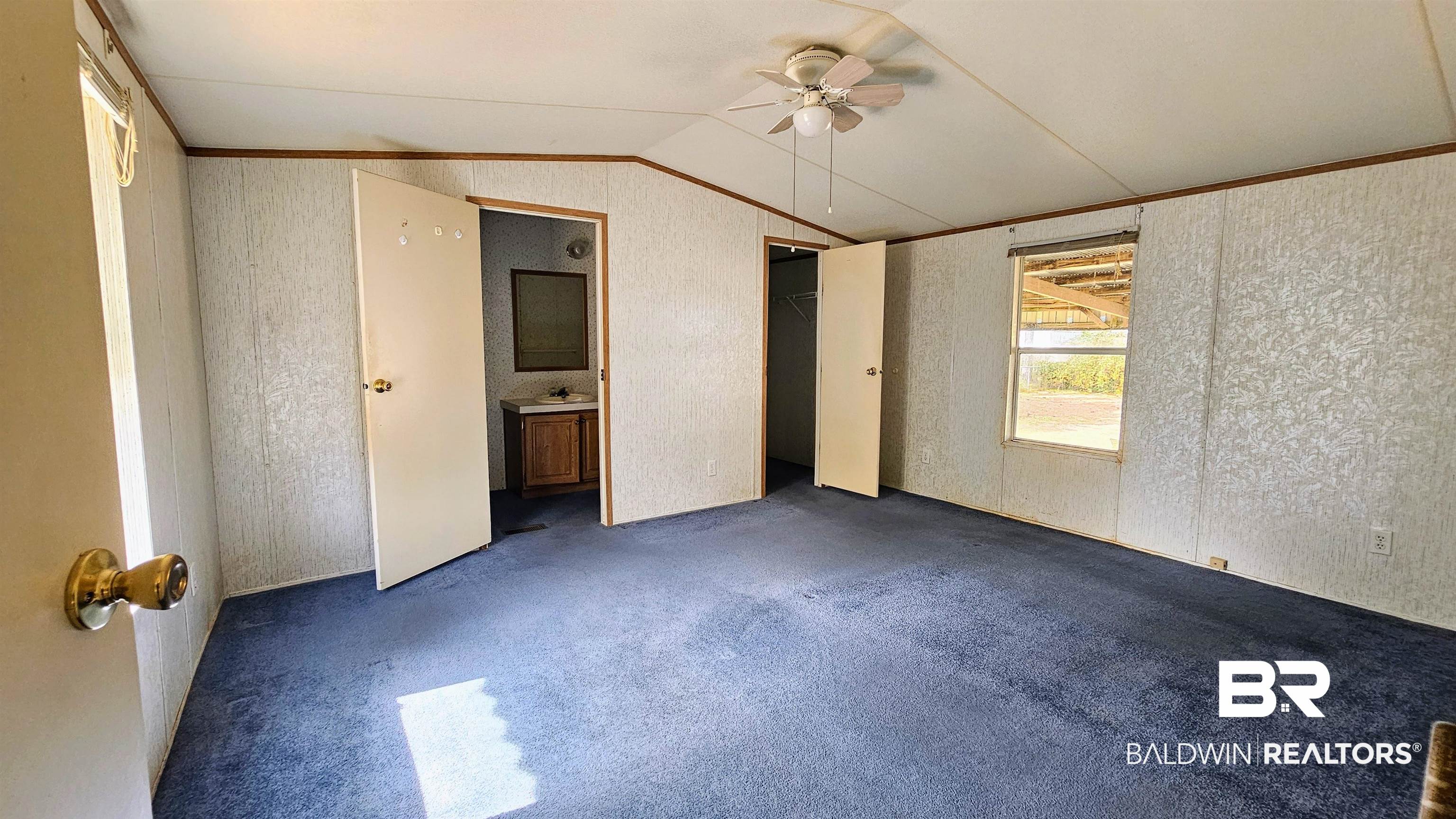 18659 Bull Springs Road Robertsdale, AL 36567 - Photo 10 of 25 Unfurnished bedroom featuring lofted ceiling, sink, ornamental molding, dark carpet, and ceiling fan