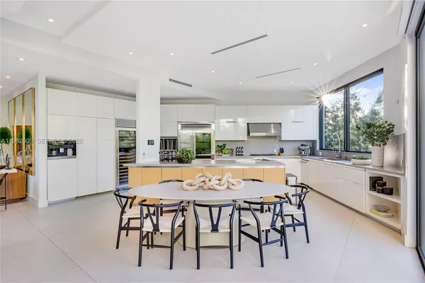 a large white kitchen with a large window