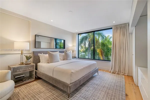 a bedroom with a bed and a large window