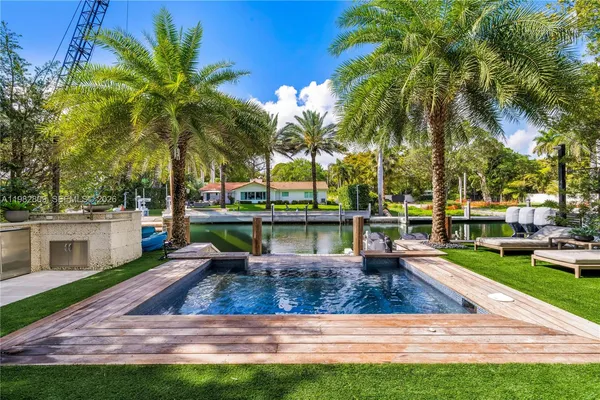 a view of a swimming pool with a patio and a yard