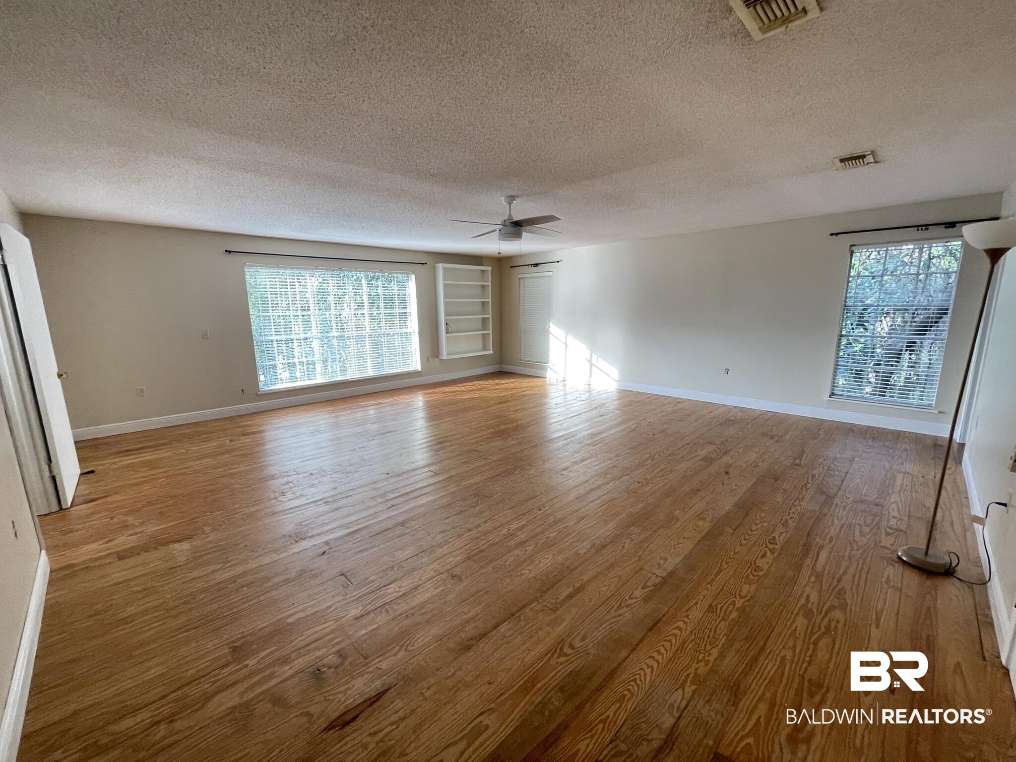 6621 Purvis Road Daphne, AL 36527 - Photo 35 of 59 Unfurnished room featuring built in shelves, light wood finished floors, ceiling fan, and a textured ceiling
