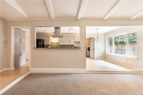 a view of a kitchen with furniture and wooden floor