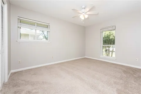 an empty room with a window and a ceiling fan