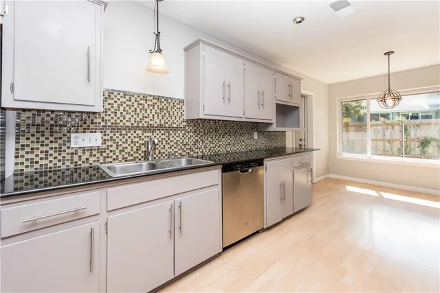 a kitchen with granite countertop white cabinets and white appliances