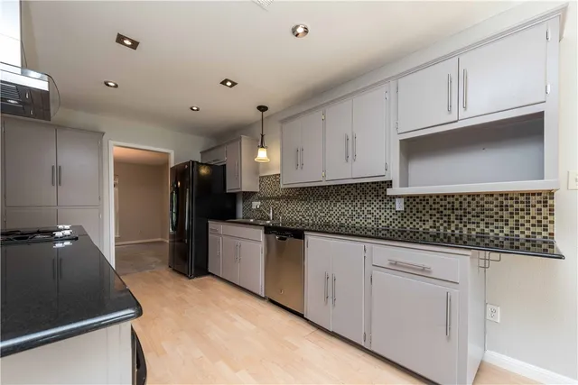 a kitchen with granite countertop white cabinets and stainless steel appliances