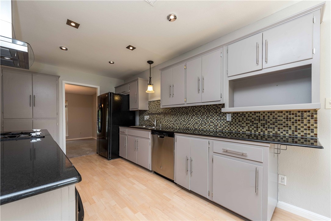 5505 Pendleton Lane Austin, TX 78723 - Photo 27 of 30 a kitchen with granite countertop white cabinets and stainless steel appliances