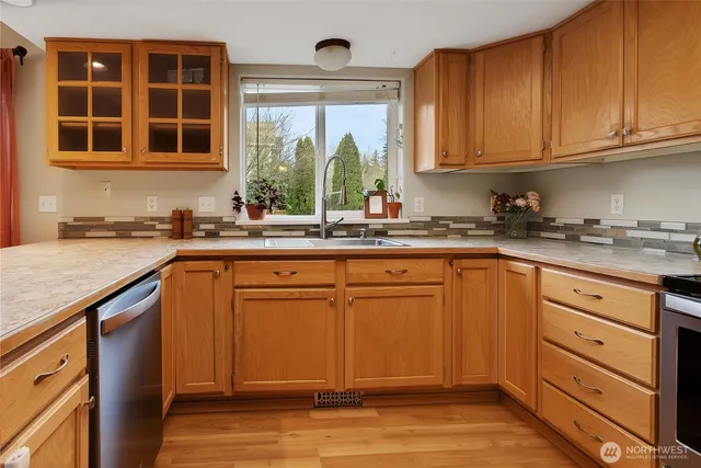 a kitchen with stainless steel appliances granite countertop a sink stove and cabinets
