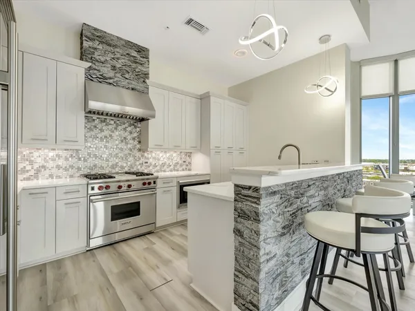 a kitchen with stainless steel appliances granite countertop a stove a sink and a microwave