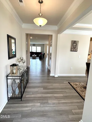 a view of a hallway view with wooden floor and a chandelier