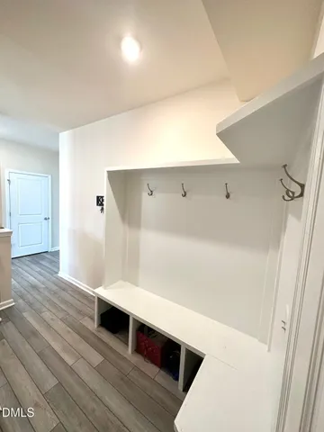 a hallway view with wooden floor and staircase