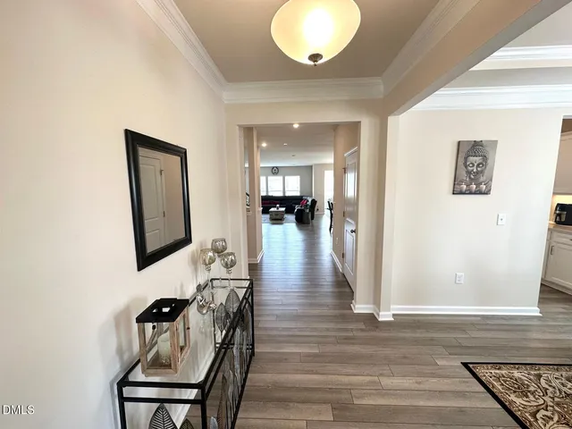 a view of a hallway with wooden floor and a chandelier