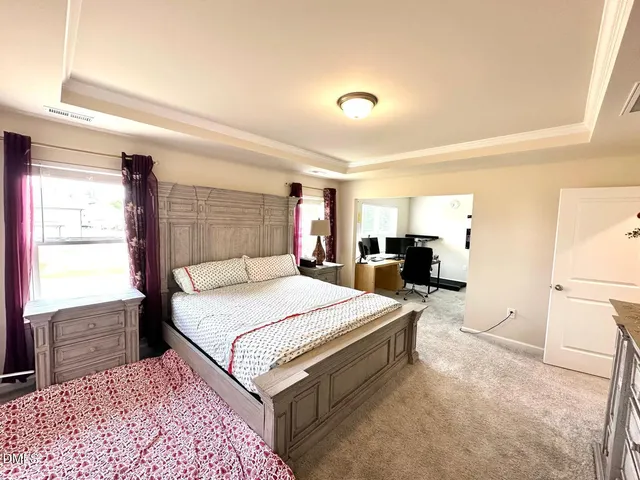 a spacious bedroom with a bed and a dresser