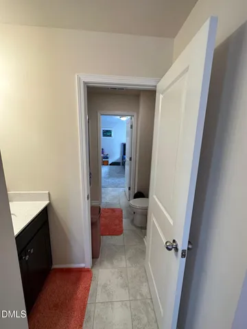 a view of a hallway and a livingroom with furniture