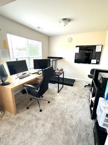 a view of a workspace with furniture and a window