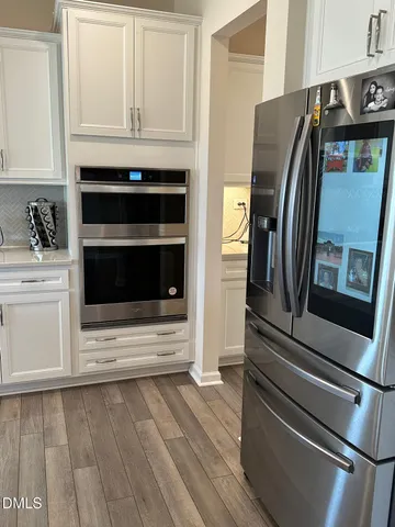 a kitchen with granite countertop white cabinets and stainless steel appliances