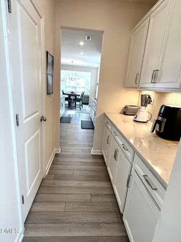 a large white kitchen with granite countertop a refrigerator