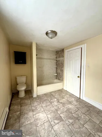 a bathroom with a toilet a mirror and a shower