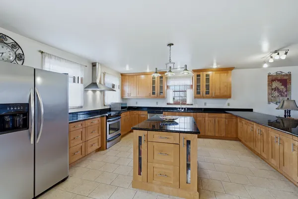 a kitchen with stainless steel appliances granite countertop a sink and a refrigerator