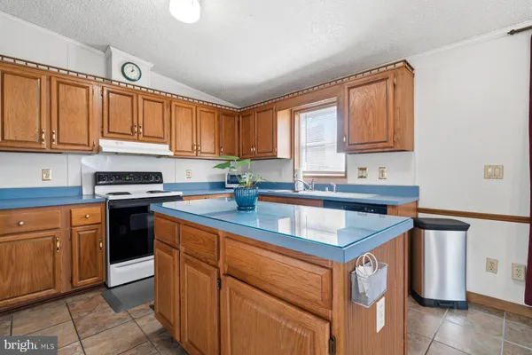 a kitchen with granite countertop a sink stove and cabinets
