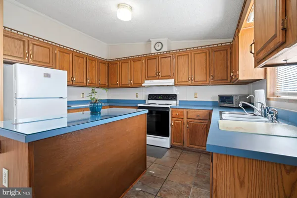 a kitchen with stainless steel appliances granite countertop a refrigerator sink stove and large window