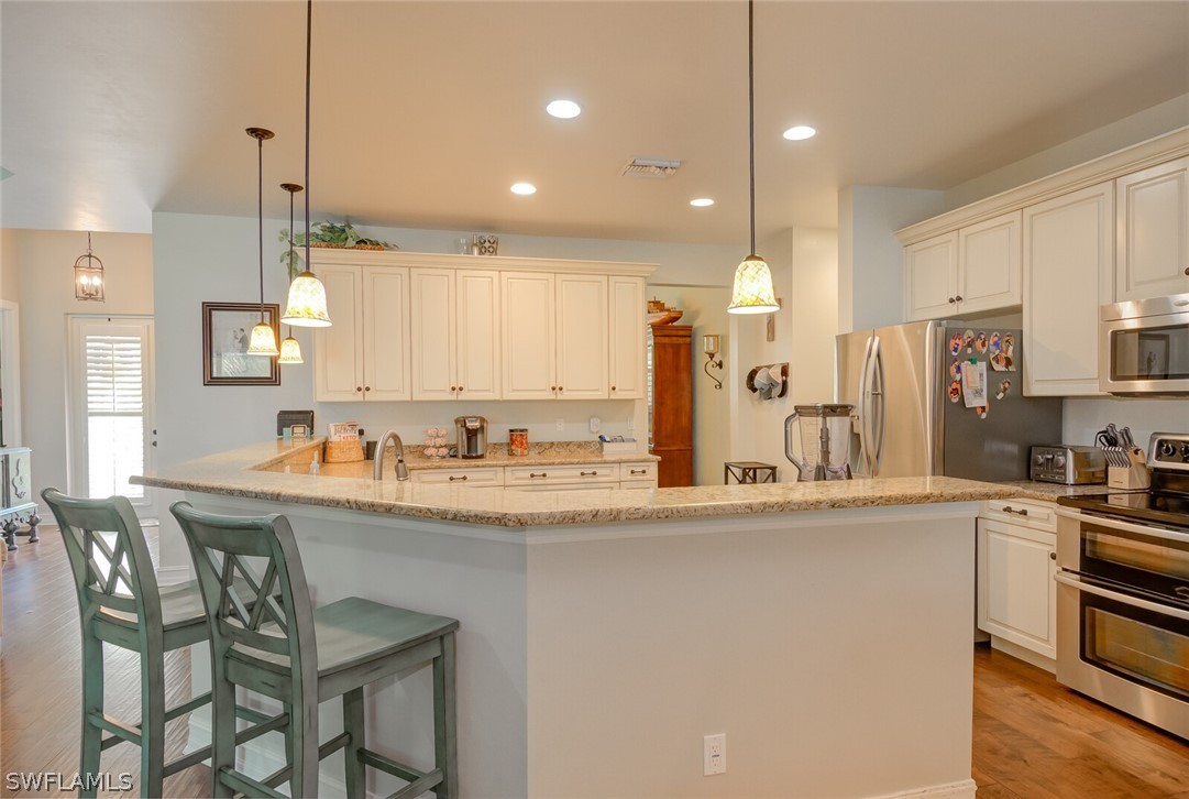 4030 Staley Road Fort Myers, FL 33905 - Photo 16 of 35 a kitchen with stainless steel appliances kitchen island a refrigerator and a stove