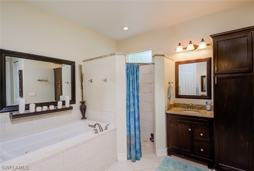 4030 Staley Road Fort Myers, FL 33905 - Photo 27 of 35 a bathroom with a tub a double vanity sink and mirror