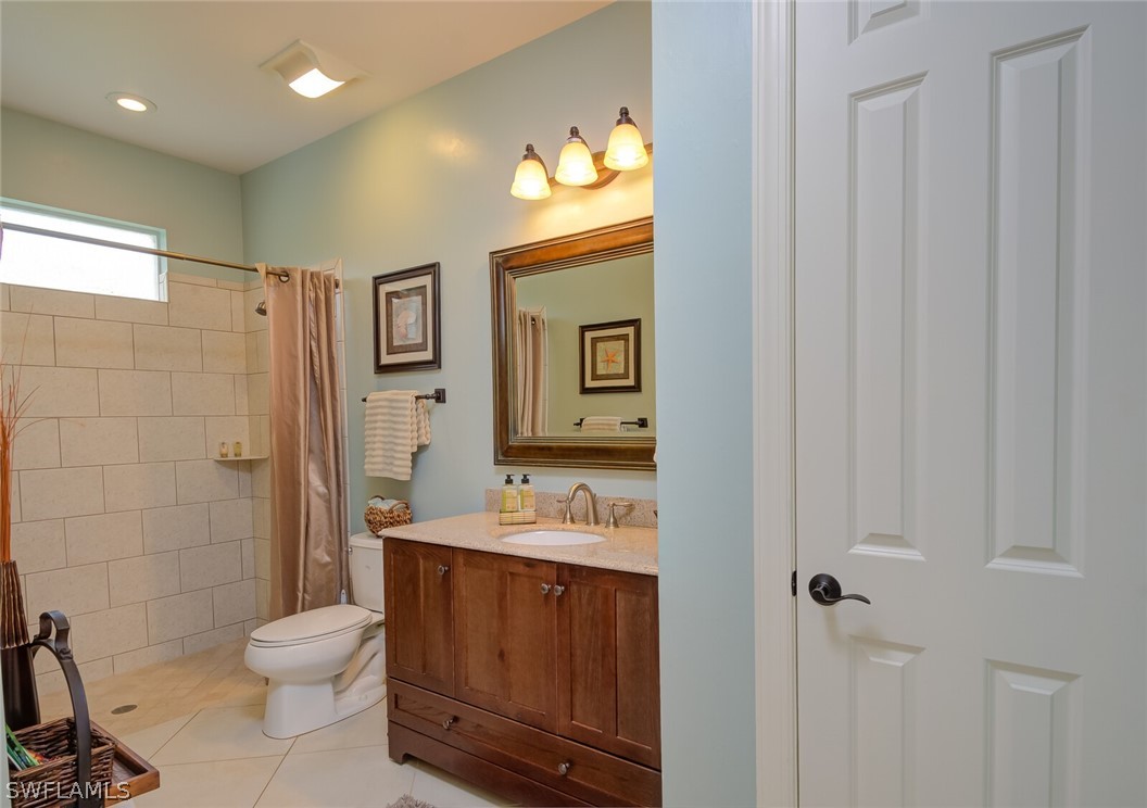 4030 Staley Road Fort Myers, FL 33905 - Photo 34 of 35 a bathroom with a granite countertop toilet a sink and a mirror